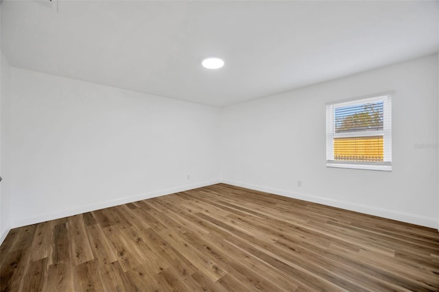 spare room featuring wood finished floors and baseboards