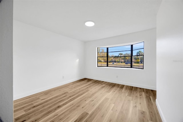 unfurnished room featuring light wood finished floors and baseboards