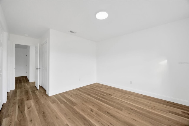 spare room with light wood-type flooring and baseboards
