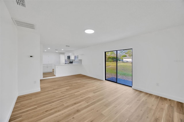 unfurnished living room with baseboards, light wood finished floors, and recessed lighting