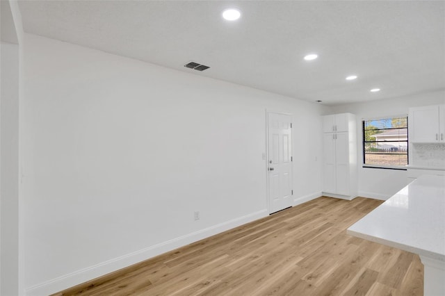 empty room with recessed lighting, light wood finished floors, and baseboards