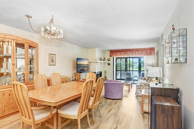 172 Lakeview Way Unit 172, Oldsmar, FL 34677 - dining room featuring light wood-style floors, a chandelier, and a textured ceiling