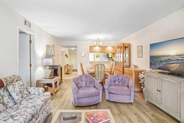 172 Lakeview Way Unit 172, Oldsmar, FL 34677 - living room featuring light wood finished floors, a chandelier, and a textured ceiling