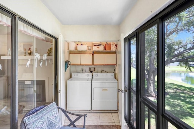 172 Lakeview Way Unit 172, Oldsmar, FL 34677 - washroom featuring washing machine and dryer, a water view, and light tile patterned flooring