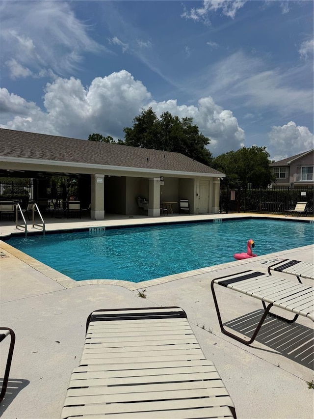 community pool featuring fence and a patio