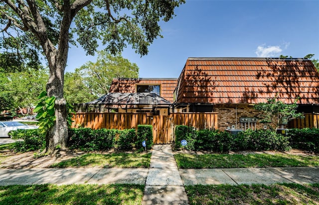 2706 11th Ct, Palm Harbor, FL 34684 - view of front of home with brick siding, mansard roof, and a tiled roof