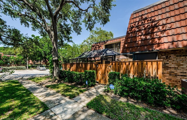 2706 11th Ct, Palm Harbor, FL 34684 - view of home's exterior featuring brick siding, a tiled roof, and mansard roof