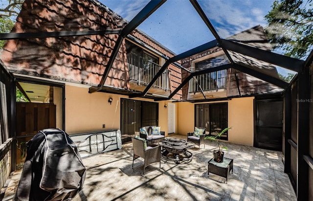 2706 11th Ct, Palm Harbor, FL 34684 - back of house featuring a balcony, outdoor lounge area, glass enclosure, a patio, and stucco siding