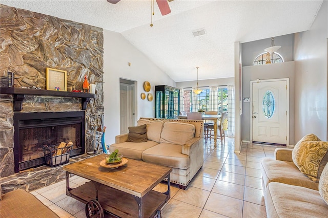 1024 Dockside Dr, Lutz, FL 33559 - living area featuring a ceiling fan, lofted ceiling, light tile patterned flooring, a textured ceiling, and a stone fireplace