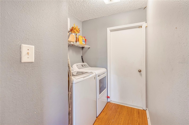 1024 Dockside Dr, Lutz, FL 33559 - laundry room with washing machine and clothes dryer, light wood-type flooring, a textured ceiling, and a textured wall