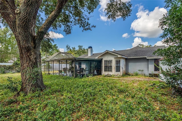 1024 Dockside Dr, Lutz, FL 33559 - rear view of property featuring a sunroom, a chimney, and stucco siding