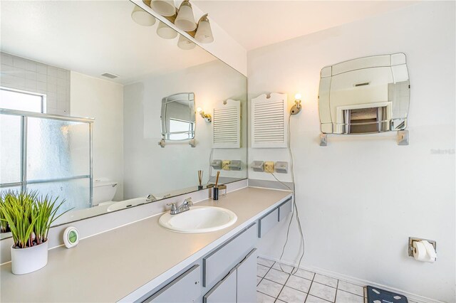 1024 Dockside Dr, Lutz, FL 33559 - bathroom with tile patterned flooring, toilet, a shower with shower door, vanity, and baseboards