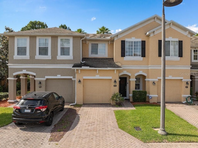 2417 Passamonte Dr Unit 1E, Winter Park, FL 32792 - multi unit property featuring driveway, an attached garage, stucco siding, and a front lawn