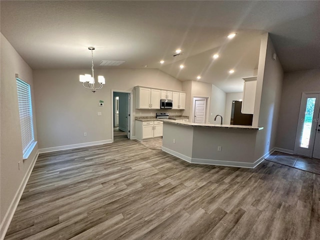 1259 Groveland Ln, Lakeland, FL 33811 - kitchen with appliances with stainless steel finishes, a chandelier, dark wood-style floors, baseboards, and white cabinetry