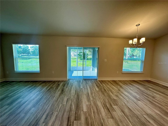 1259 Groveland Ln, Lakeland, FL 33811 - empty room with a chandelier, wood finished floors, baseboards, and plenty of natural light