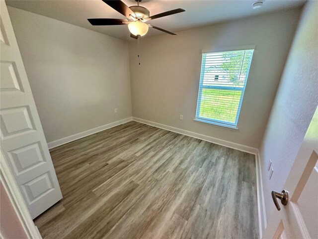 1259 Groveland Ln, Lakeland, FL 33811 - empty room featuring wood finished floors, a ceiling fan, baseboards, and a smoke detector