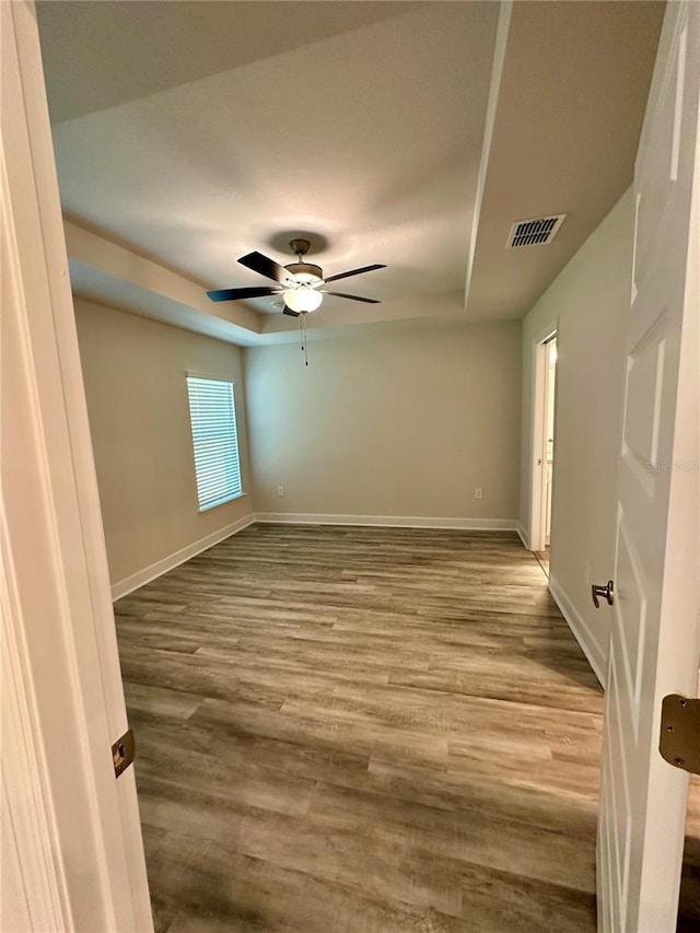 1259 Groveland Ln, Lakeland, FL 33811 - unfurnished room with wood finished floors, baseboards, and a raised ceiling