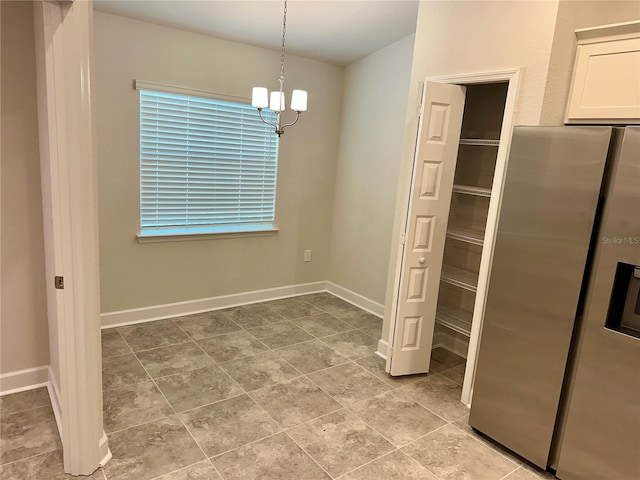1259 Groveland Ln, Lakeland, FL 33811 - unfurnished dining area with a chandelier and baseboards