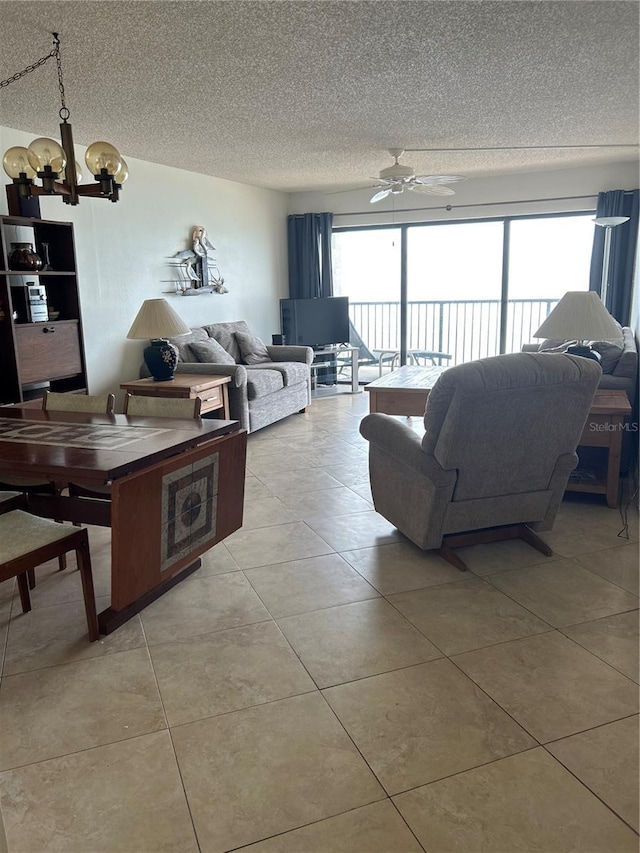 14950 Gulf Blvd Unit 603, Madeira Beach, FL 33708 - living area featuring a chandelier, a textured ceiling, light tile patterned floors, and a ceiling fan