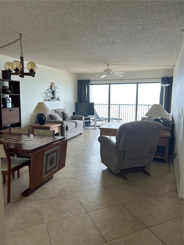 14950 Gulf Blvd Unit 603, Madeira Beach, FL 33708 - living room with a textured ceiling, a chandelier, light tile patterned floors, and a ceiling fan