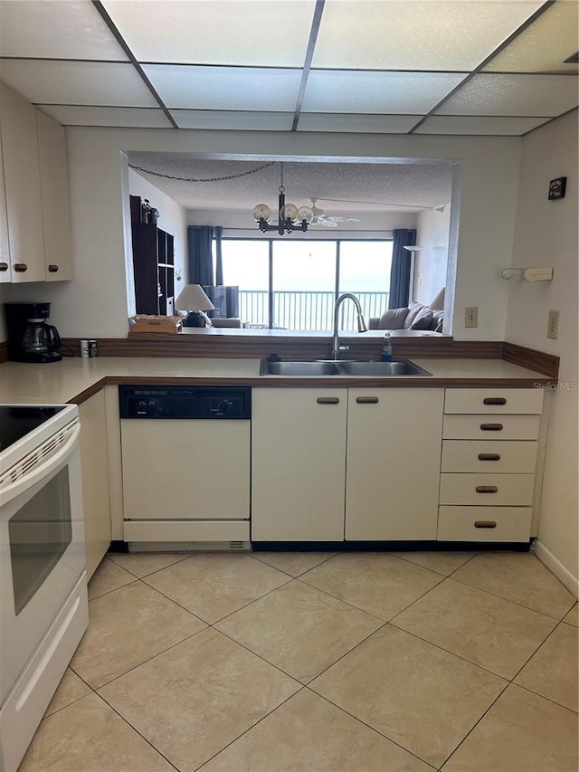 14950 Gulf Blvd Unit 603, Madeira Beach, FL 33708 - kitchen with white appliances, a sink, a chandelier, white cabinets, and light tile patterned floors