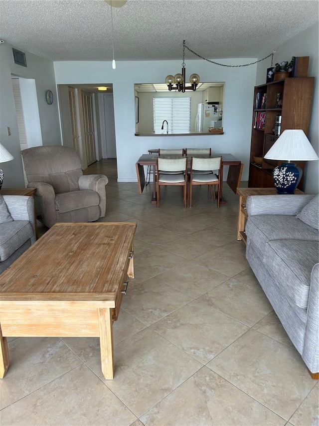 14950 Gulf Blvd Unit 603, Madeira Beach, FL 33708 - living room featuring a chandelier and a textured ceiling