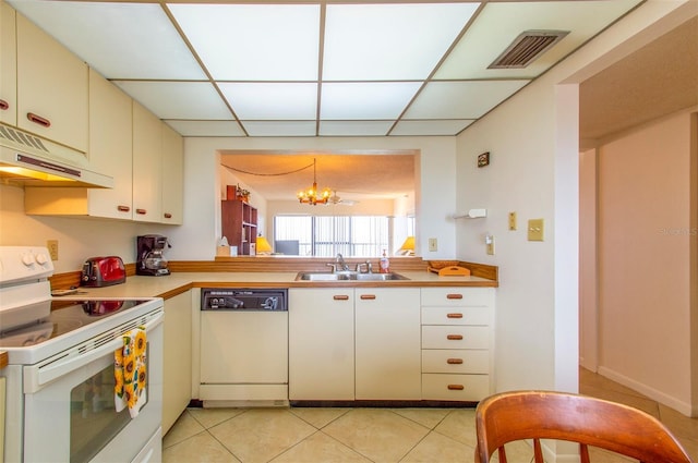 14950 Gulf Blvd Unit 603, Madeira Beach, FL 33708 - kitchen with white appliances, under cabinet range hood, a chandelier, a sink, and light tile patterned floors