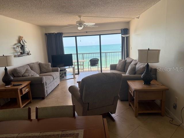 14950 Gulf Blvd Unit 603, Madeira Beach, FL 33708 - living area with ceiling fan, a textured ceiling, and light tile patterned flooring