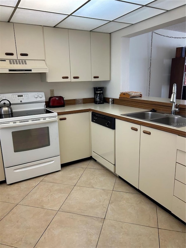 14950 Gulf Blvd Unit 603, Madeira Beach, FL 33708 - kitchen featuring white appliances, under cabinet range hood, a sink, light tile patterned floors, and a paneled ceiling