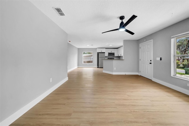 8504 N 17th St, Tampa, FL 33604 - unfurnished living room with healthy amount of natural light, baseboards, a ceiling fan, and a textured ceiling