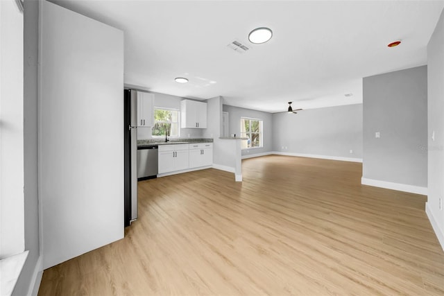 8504 N 17th St, Tampa, FL 33604 - unfurnished living room with a sink, light wood-type flooring, and baseboards