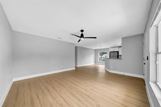 8504 N 17th St, Tampa, FL 33604 - unfurnished living room with ceiling fan, light wood-style flooring, and baseboards