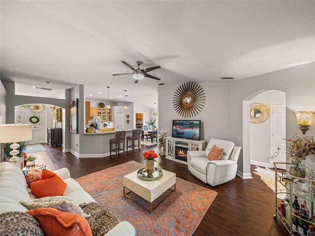 18003 Arbor Crest Dr, Tampa, FL 33647 - living area featuring arched walkways, ceiling fan, wood finished floors, baseboards, and a textured ceiling