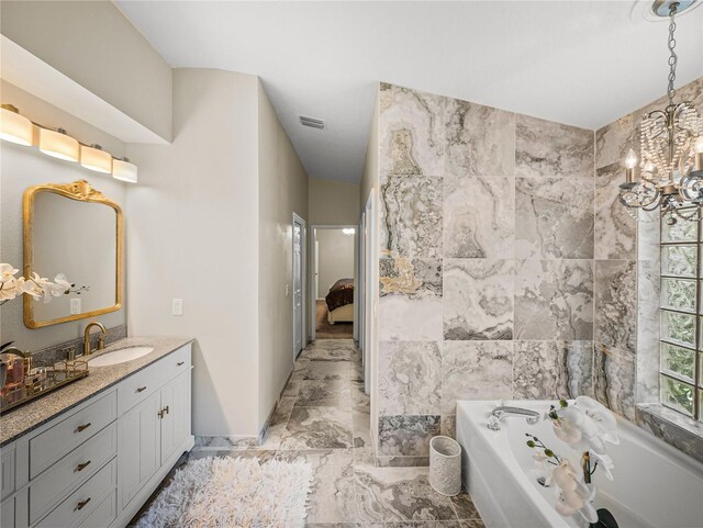 18003 Arbor Crest Dr, Tampa, FL 33647 - ensuite bathroom with marble look tile flooring, vanity, a garden tub, and a chandelier