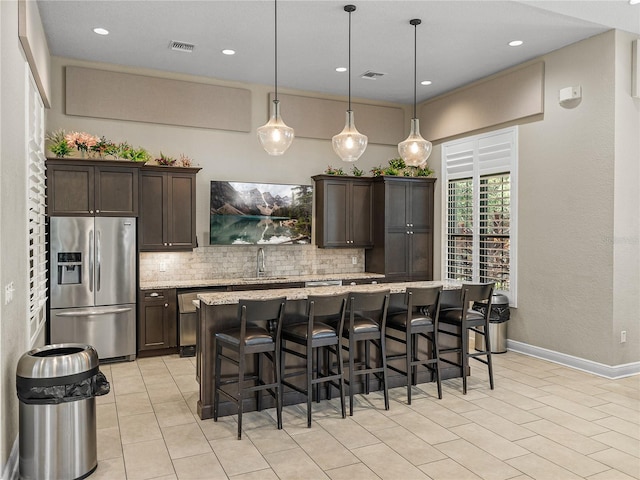18003 Arbor Crest Dr, Tampa, FL 33647 - kitchen with stainless steel appliances, a sink, decorative backsplash, light tile patterned floors, and dark brown cabinets