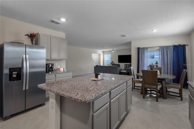 5189 Greenheart Ave, Mount Dora, FL 32757 - kitchen featuring stainless steel fridge with ice dispenser, gray cabinetry, a kitchen island, light stone counters, and recessed lighting