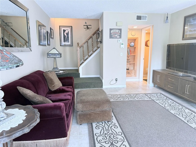 11764 Raintree Dr Unit 0, Temple Terrace, FL 33617 - living room featuring stairway, a textured ceiling, baseboards, and tile patterned flooring