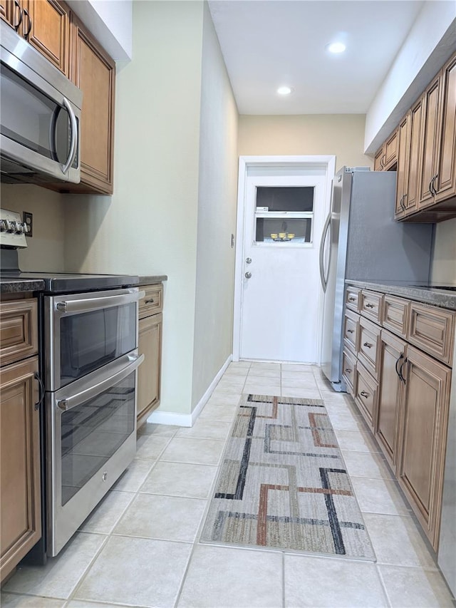 11764 Raintree Dr Unit 0, Temple Terrace, FL 33617 - kitchen featuring stainless steel appliances, light tile patterned flooring, recessed lighting, brown cabinets, and dark countertops