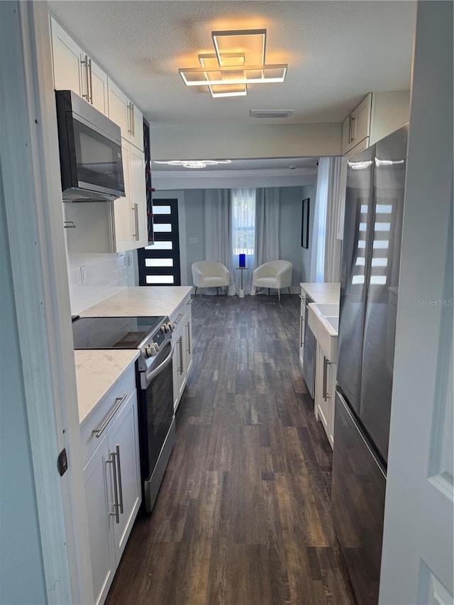 3008 E 38th Ave, Tampa, FL 33610 - kitchen with range with electric cooktop, freestanding refrigerator, dark wood-style floors, white cabinets, and light stone countertops