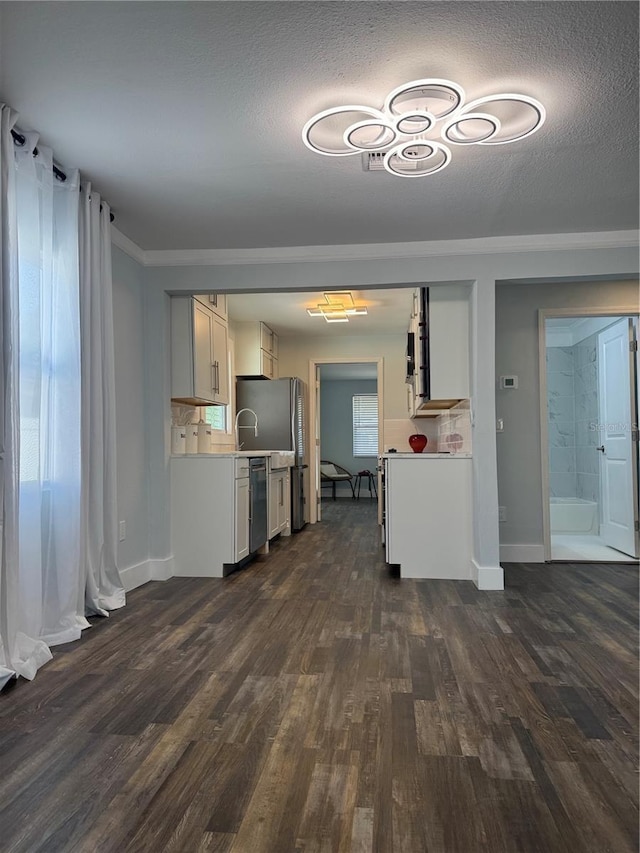 3008 E 38th Ave, Tampa, FL 33610 - kitchen featuring light countertops, dark wood finished floors, stainless steel dishwasher, baseboards, and a textured ceiling