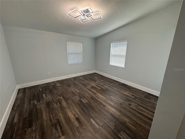 3008 E 38th Ave, Tampa, FL 33610 - unfurnished room featuring dark wood-style flooring, vaulted ceiling, baseboards, and a textured ceiling