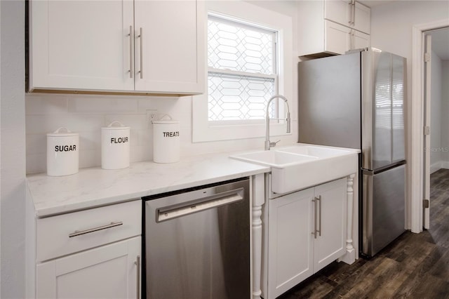 3008 E 38th Ave, Tampa, FL 33610 - kitchen with stainless steel appliances, dark wood-style floors, backsplash, white cabinetry, and light stone counters