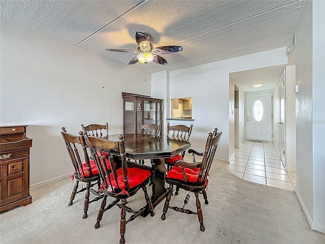 1 Boca Ciega Point Blvd Unit 215, Saint Petersburg, FL 33708 - dining space with ceiling fan, light carpet, light tile patterned flooring, a textured ceiling, and baseboards