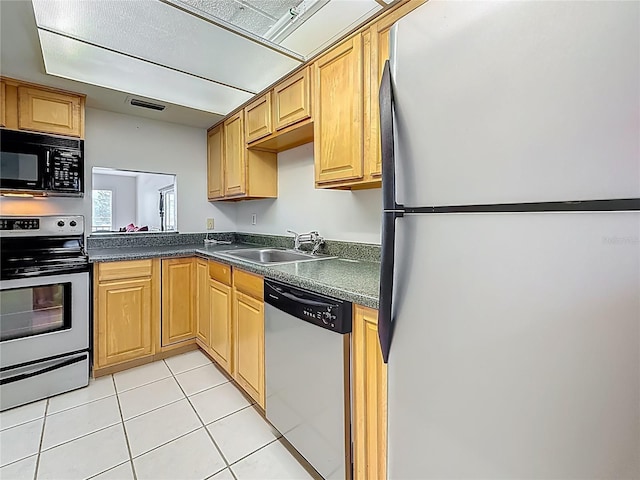 1 Boca Ciega Point Blvd Unit 215, Saint Petersburg, FL 33708 - kitchen with stainless steel appliances, a sink, dark countertops, and light tile patterned floors