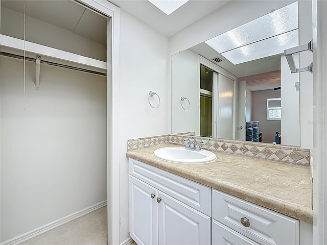 1 Boca Ciega Point Blvd Unit 215, Saint Petersburg, FL 33708 - bathroom featuring vanity, a walk in closet, and baseboards