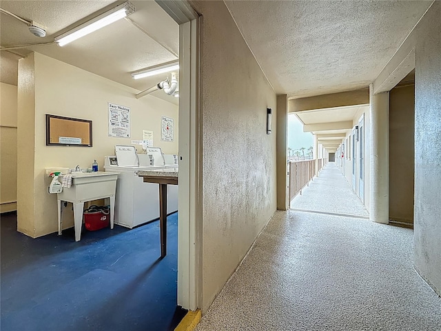1 Boca Ciega Point Blvd Unit 215, Saint Petersburg, FL 33708 - hallway featuring a textured ceiling, a textured wall, and washer and dryer