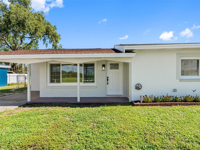 302 Patty Dr, Oldsmar, FL 34677 - view of front facade featuring a carport, covered porch, brick siding, and driveway