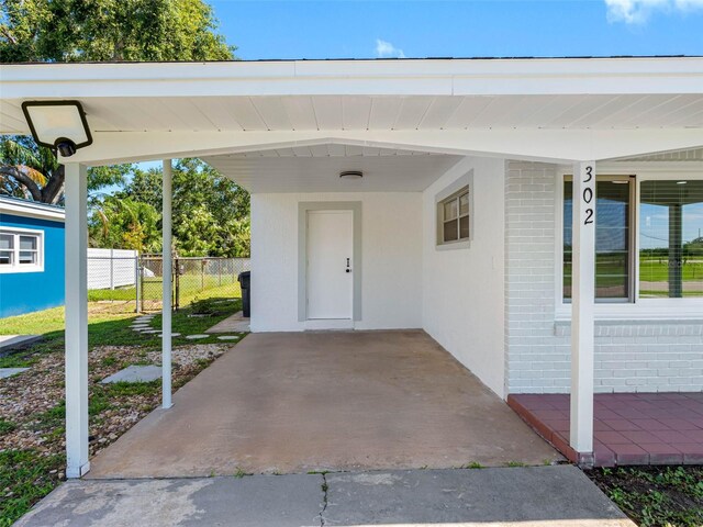 302 Patty Dr, Oldsmar, FL 34677 - property entrance with brick siding and a carport