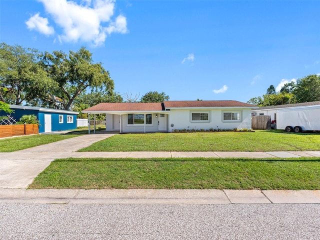 302 Patty Dr, Oldsmar, FL 34677 - ranch-style house with driveway, an attached carport, and stucco siding