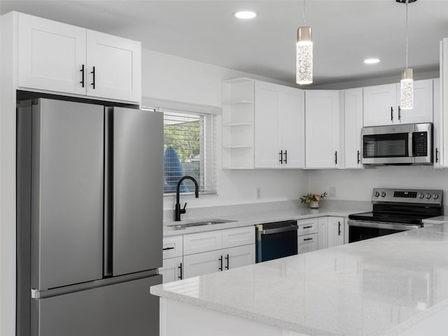 302 Patty Dr, Oldsmar, FL 34677 - kitchen featuring stainless steel appliances, white cabinetry, light stone countertops, recessed lighting, and decorative light fixtures